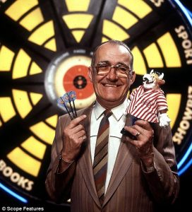 "Bullseye" host Jim Bowen in front of the famous dartboard.